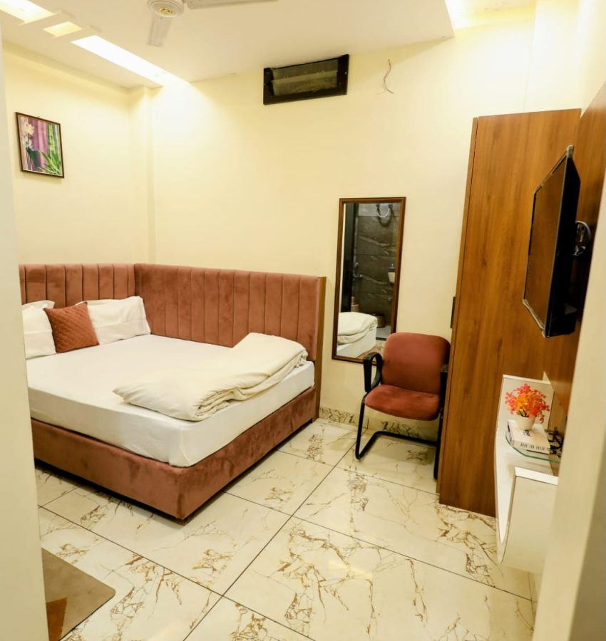 HOME 6 Deluxe room with TV, seating area and modern amenities in Maheshwar