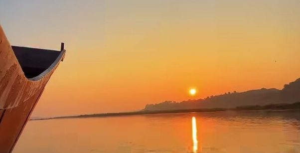Narmada River sunset with a traditional boat in Maheshwar Madhya Pradesh