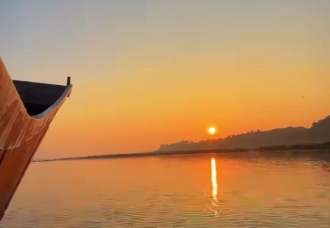 Narmada River sunset with a traditional boat in Maheshwar Madhya Pradesh